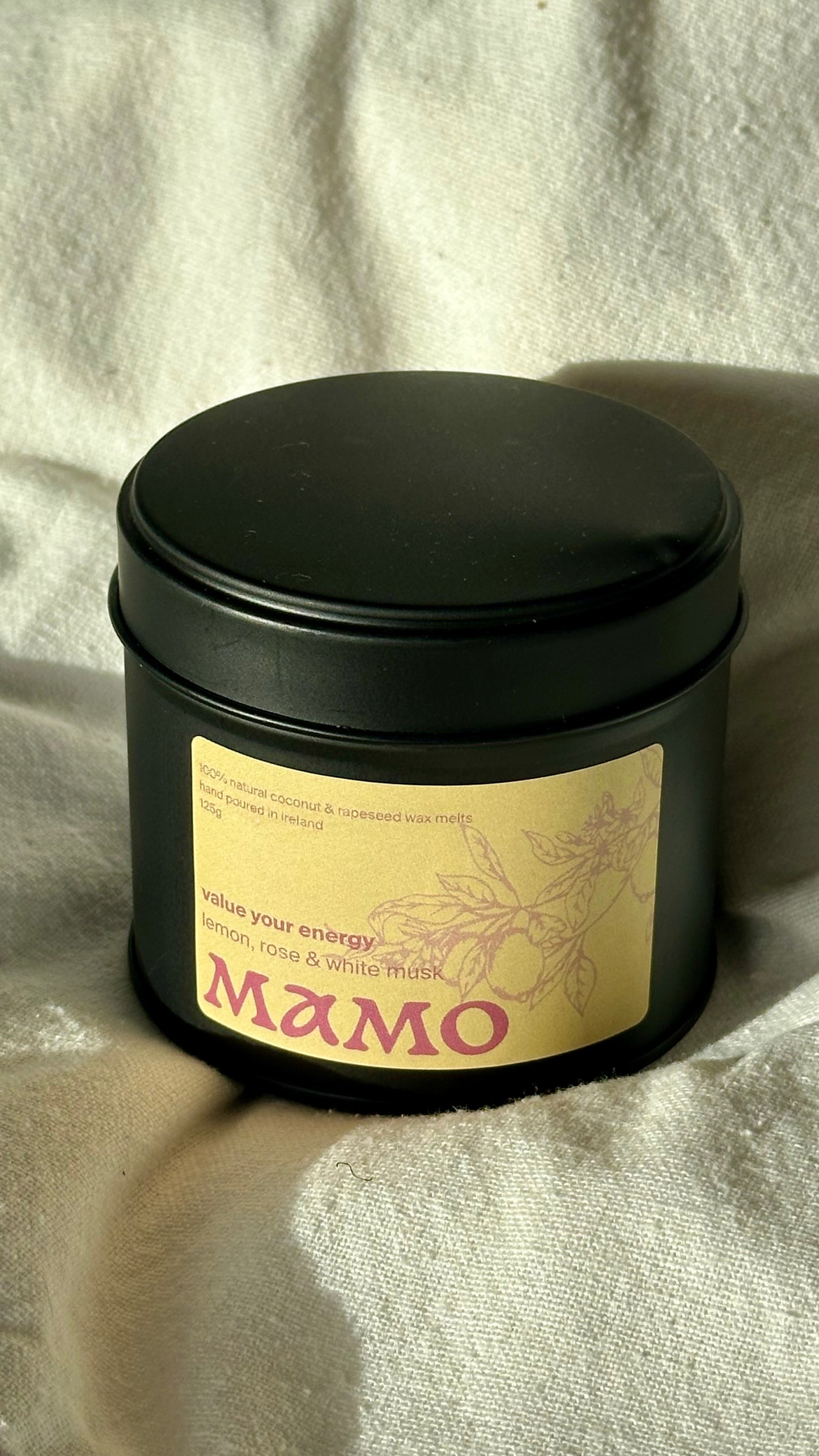 MAMO’s lemon and musk wax melts resting on soft fabric with natural light.