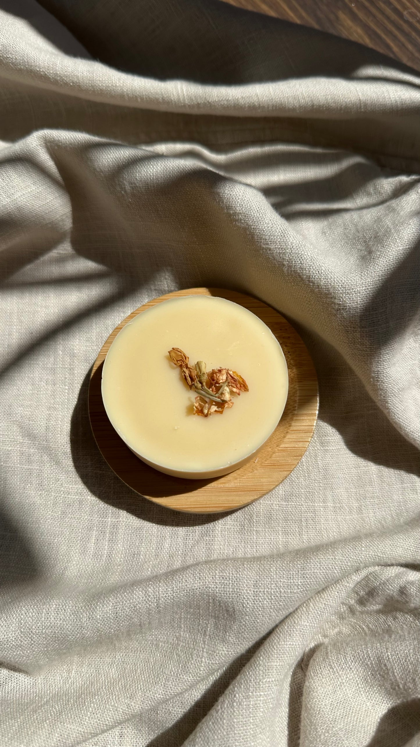 Small round container with a lid on a textured fabric surface