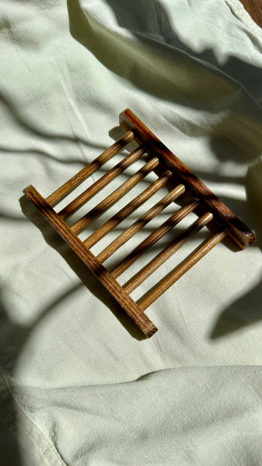 Wooden bamboo soap rack on a light fabric background