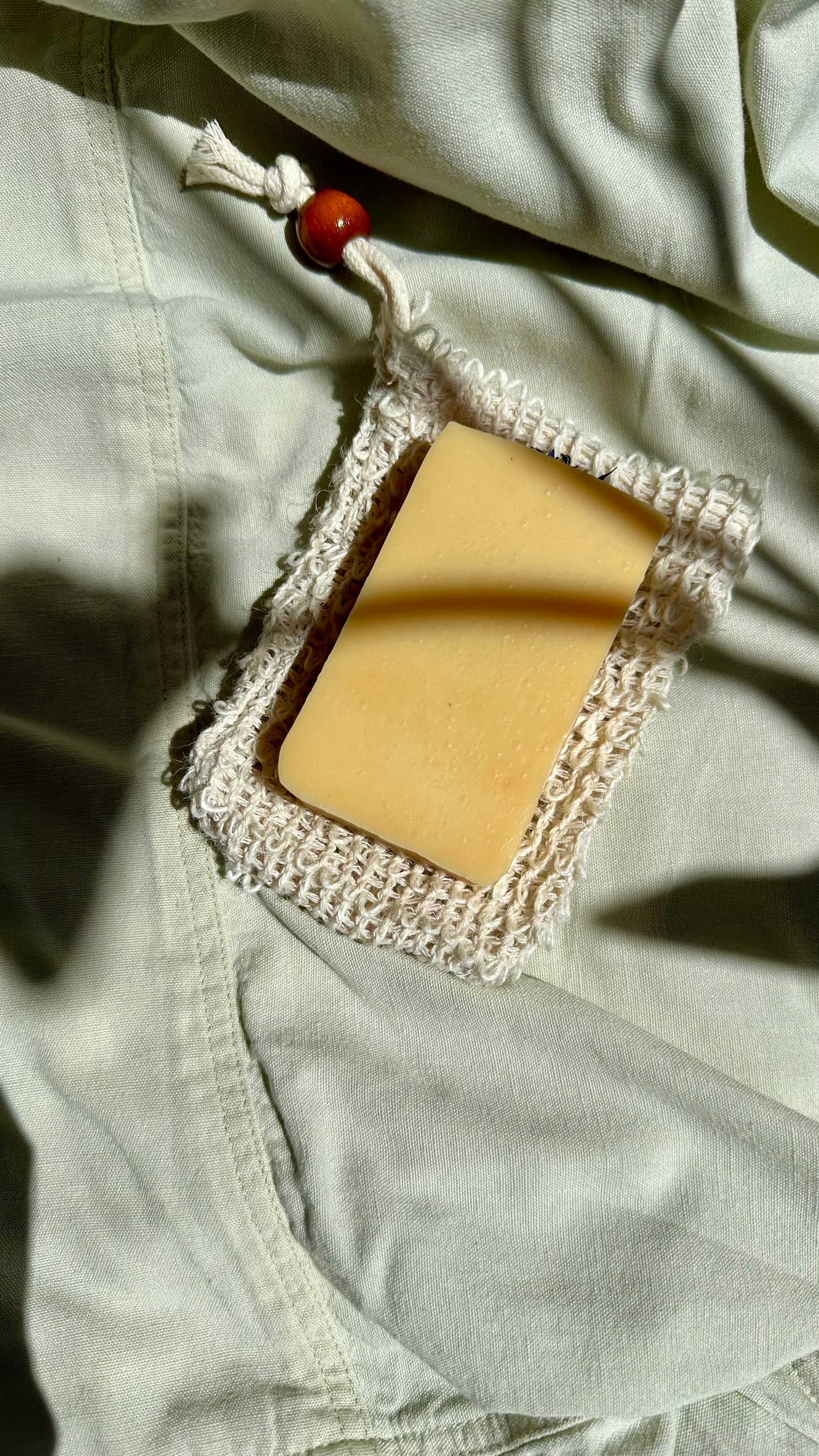 Bar of soap with a decorative lace cover on light-colored fabric