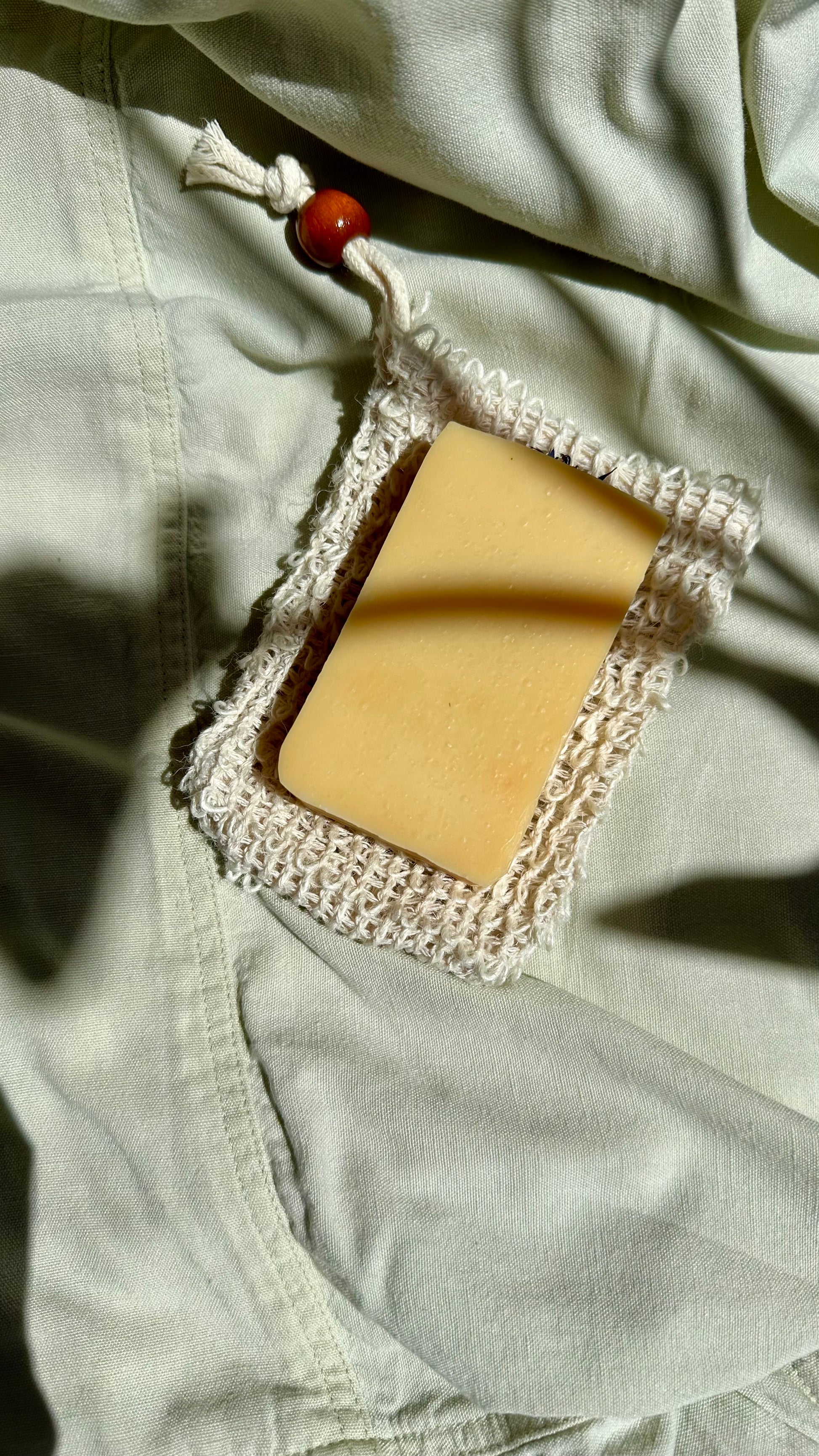 Bar of soap with a decorative lace cover on light-colored fabric
