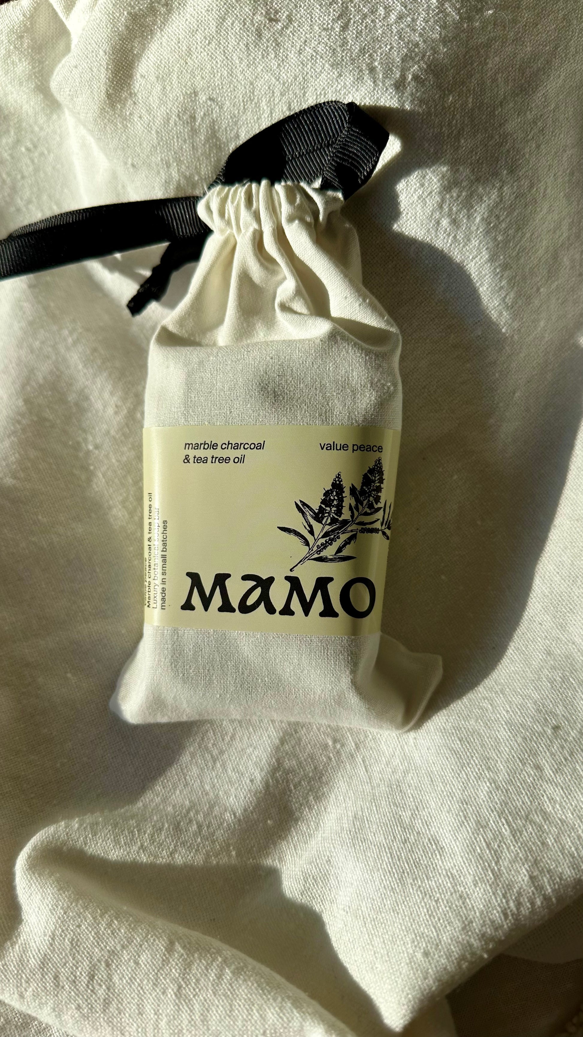 MAMO Value Peace detox soap in cotton bag on linen