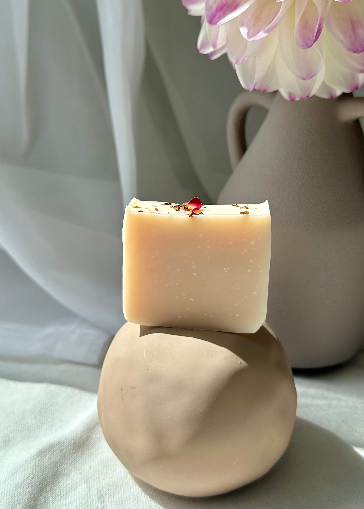 Close-up of floral citrus cold process soap with pink clay travel size