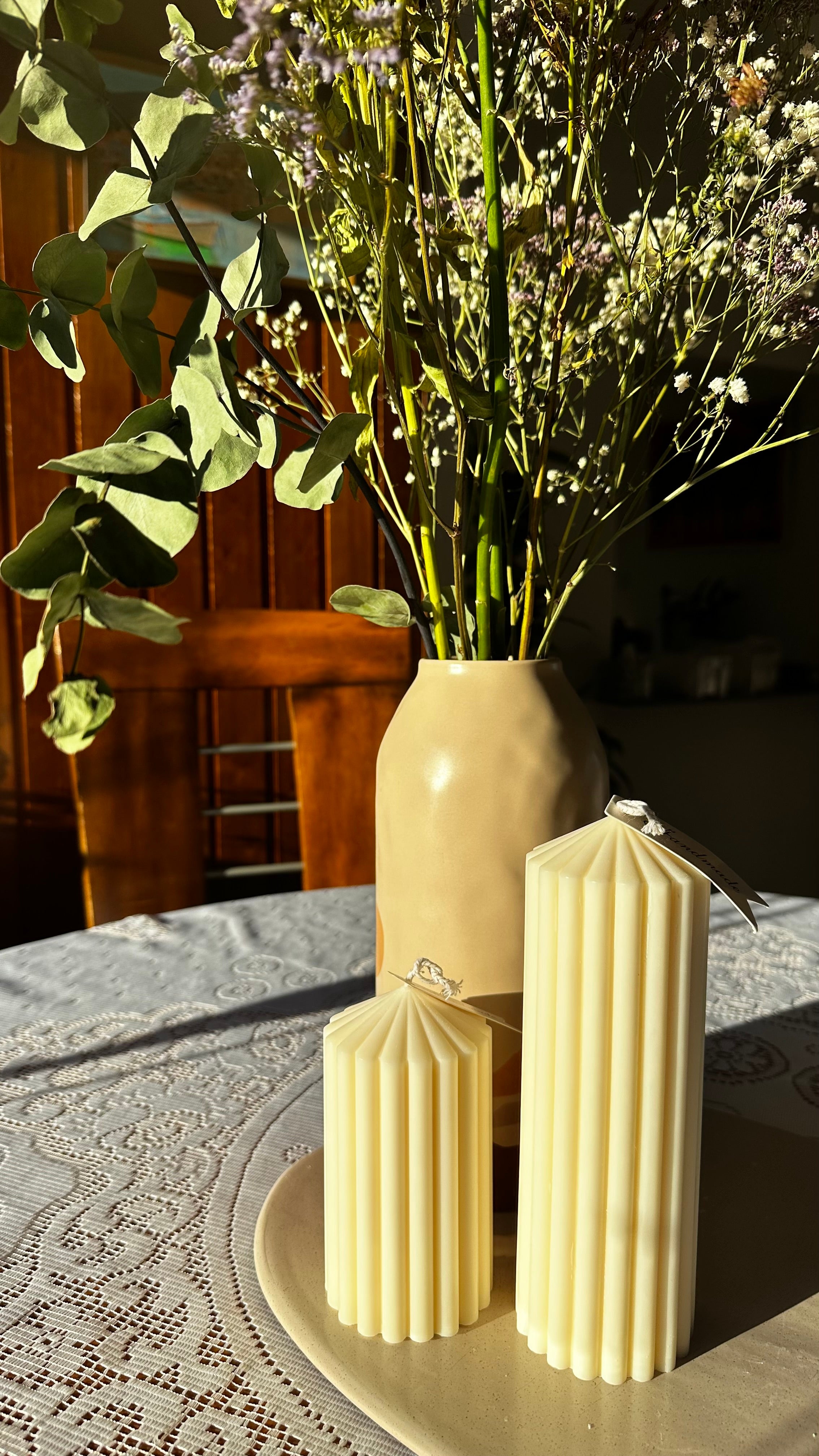 Small minimalist soy pillar candle paired with a large pillar soy candle on a dining table